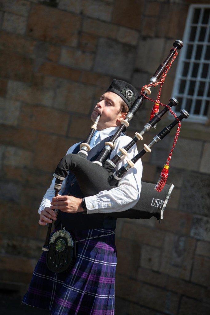 Scottish Piper Hire playing bagpipes for guests arriving to venue.